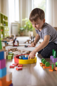 Side view of boy playing with toys at home