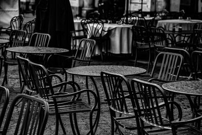 Empty chairs and tables at sidewalk coffee shop