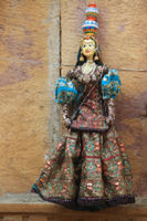 Close-up of figurine on wood against wall