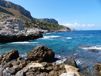 Scenic view of rocks on beach against sky