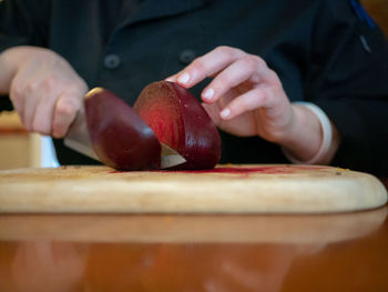 Close-up of person holding apple on table