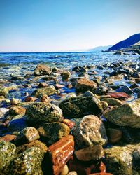 Rocks on beach against clear sky