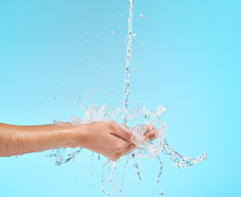 Close-up of water splashing against blue background