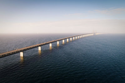 Aerial view of bridge over sea against cloudy sky