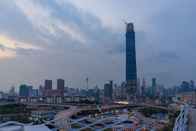 Modern buildings in city against sky during sunset