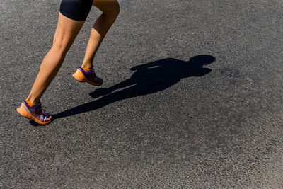 Low section of person running on road