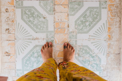 Low section of woman standing on tiled floor