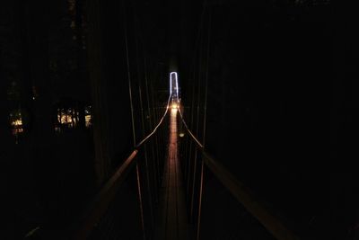 Illuminated footbridge in city at night