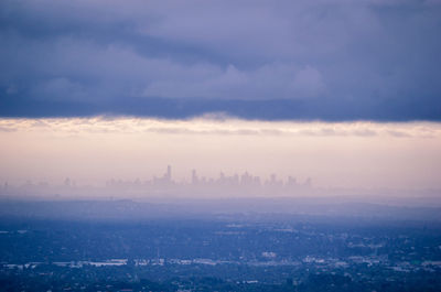 Cityscape against cloudy sky