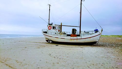 Ship on beach against sky