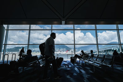 People sitting at airport against sky