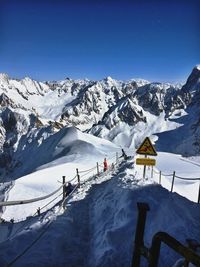 Scenic view of snowcapped mountains against clear blue sky