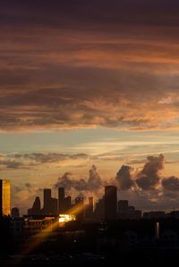 Buildings in city against sky during sunset