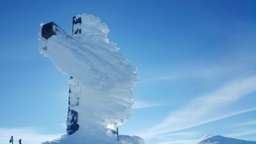 Low angle view of frozen mountain against sky