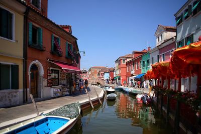 Boats moored in canal along buildings