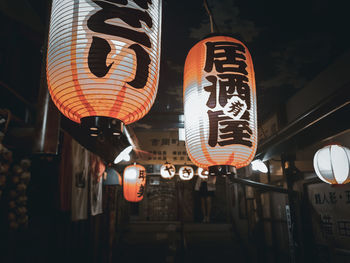 Low angle view of illuminated lanterns hanging at night