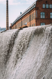 Water flowing in building against sky