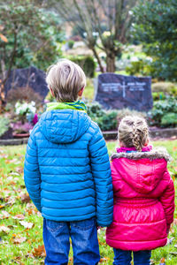 Rear view of two women standing against plants