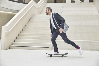 Businesssman riding skateboard at staircase