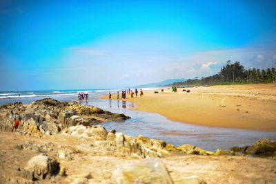 People at beach against sky