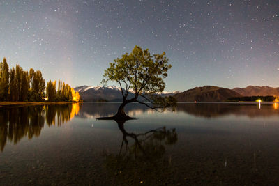 Scenic view of lake against sky at night