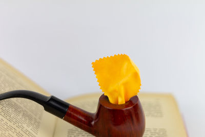 Close-up of yellow toy on table against white background