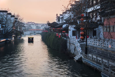 Bridge over river in city against clear sky