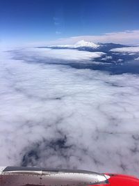 Cropped image of airplane flying over cloudscape