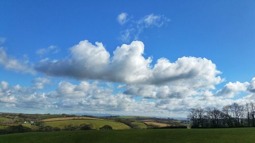 Scenic view of field against cloudy sky