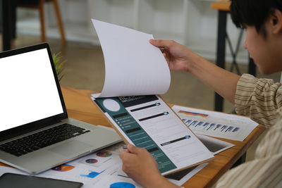 Midsection of man using laptop on table