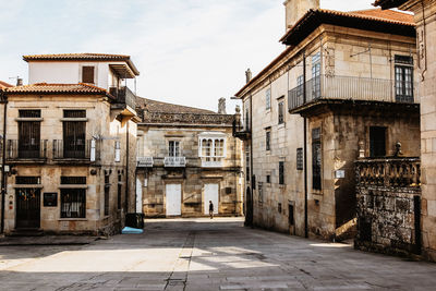 Old building by street in city against sky