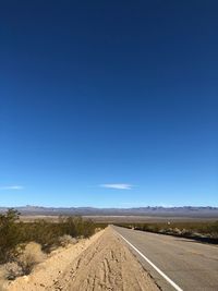 Empty road along countryside landscape