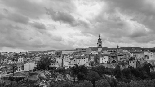 View of buildings in city against cloudy sky