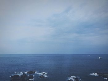 Scenic view of calm sea against cloudy sky