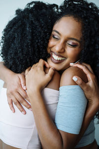 Portrait of two women of color hugging each other