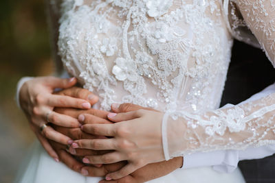 Midsection of bride holding wedding dress