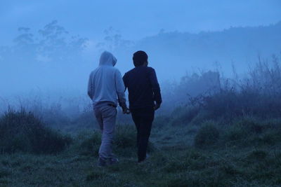 Rear view of men walking on land