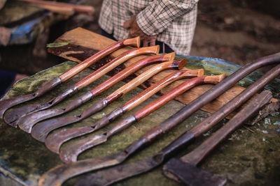 Midsection of man standing by old work tools at market stall