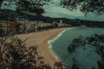 Scenic view of beach by buildings against sky