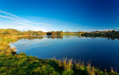 Scenic view of lake against blue sky