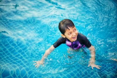 High angle view of smiling girl swimming in pool