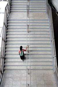 High angle view of woman moving up on staircase