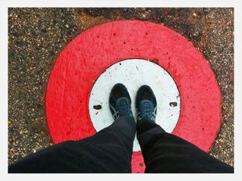 Low section of man standing on painted manhole