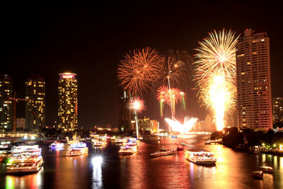 Firework display over river at night