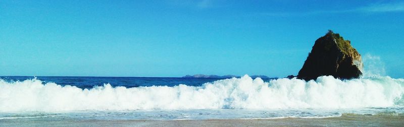 Panoramic view of sea against clear blue sky