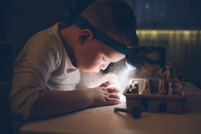 Side view of boy playing with toy