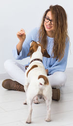 Portrait of young woman with dogs sitting on hardwood floor