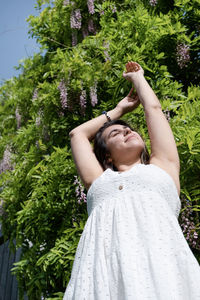 Rear view of woman standing against plants