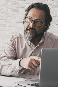 Side view of man using laptop at home