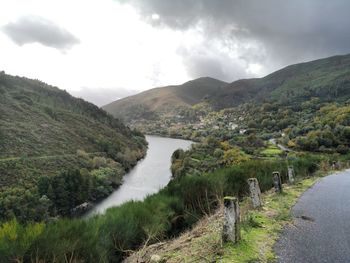Scenic view of river amidst mountains against sky